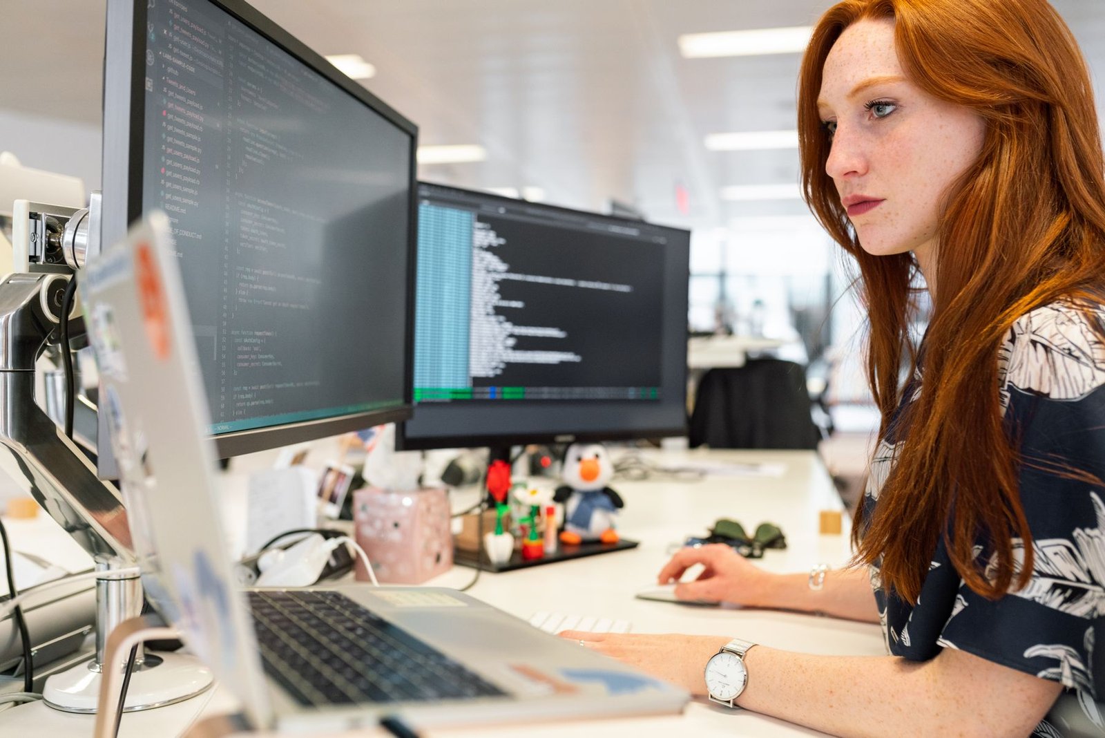 Software engineer coding across multiple monitors