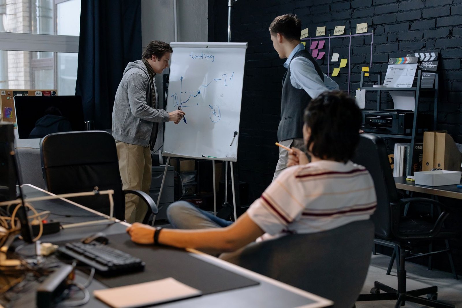 Business team reviewing ideas and strategy on a whiteboard in a modern office
