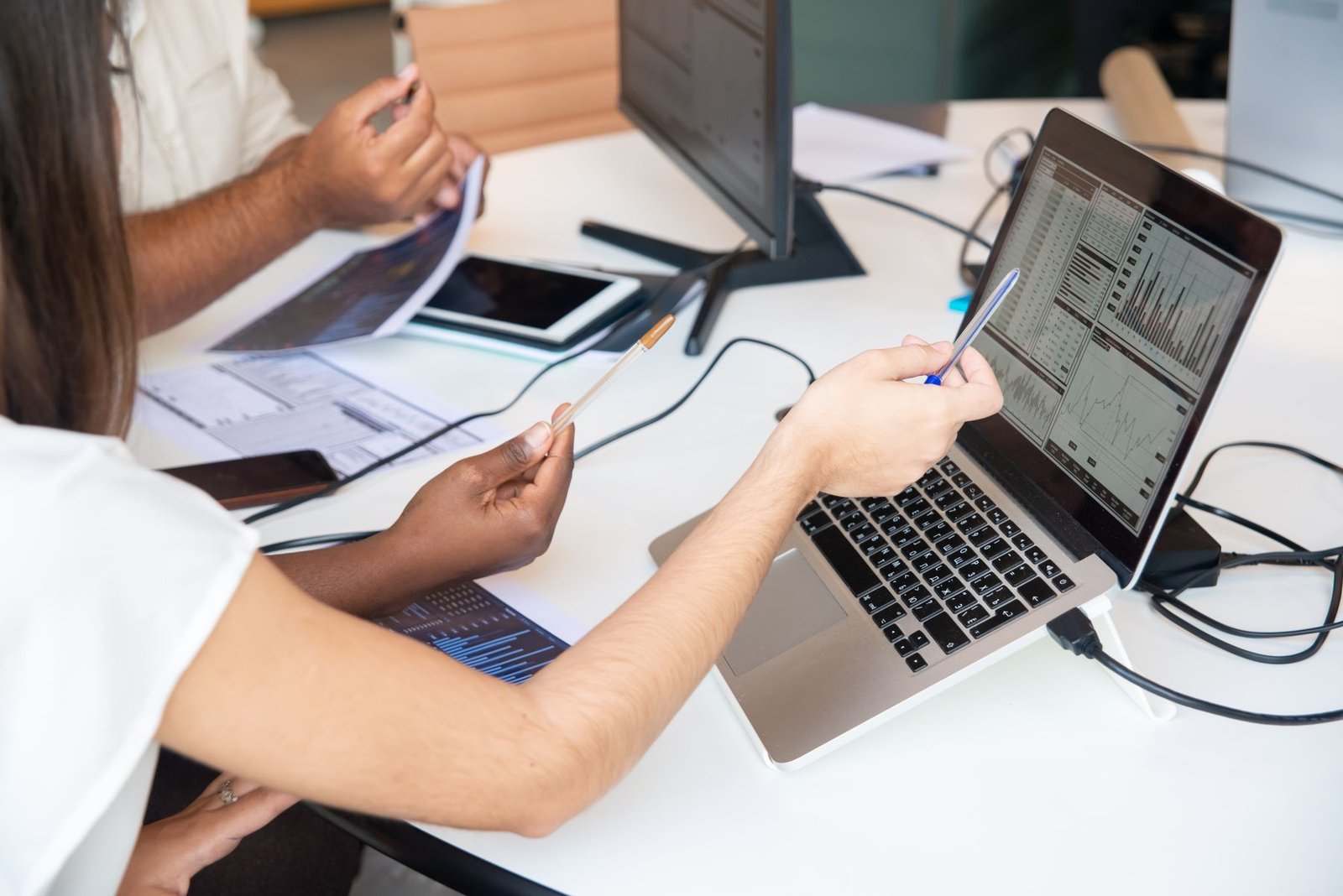 Professionals reviewing performance charts together on a laptop