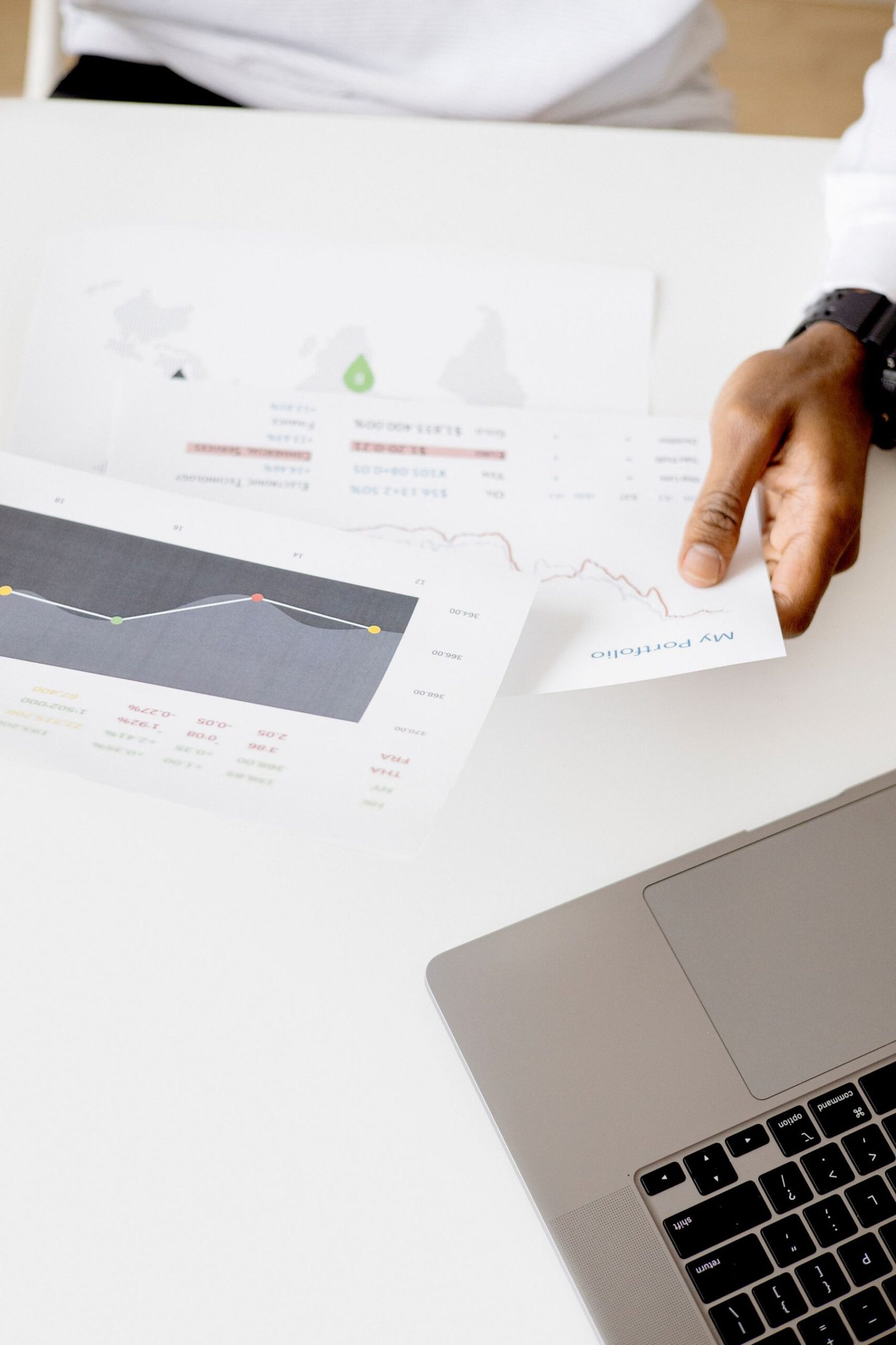 Professional reviewing business reports and charts on a laptop