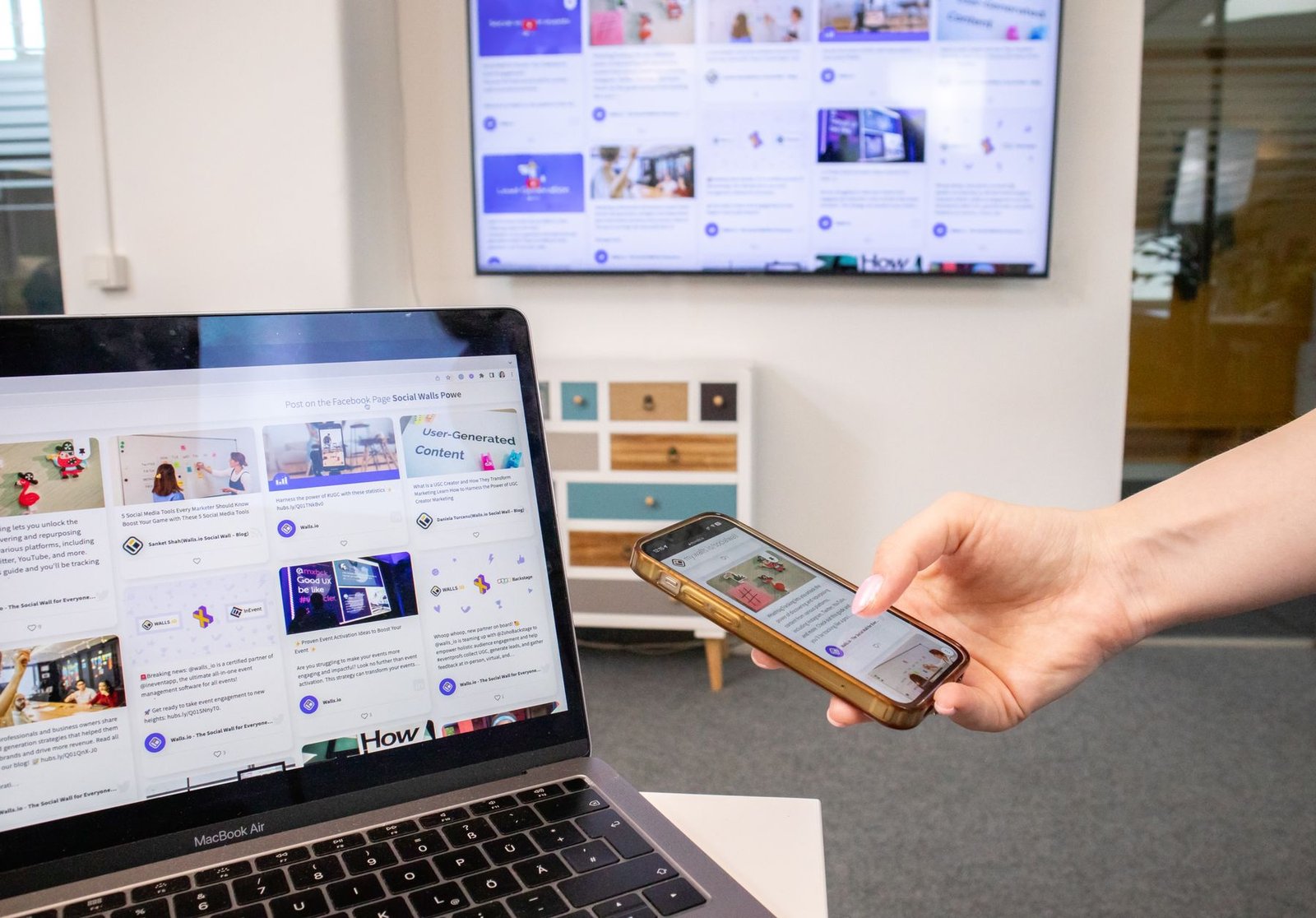 Connected laptop, smartphone and digital screens in a modern office environment
