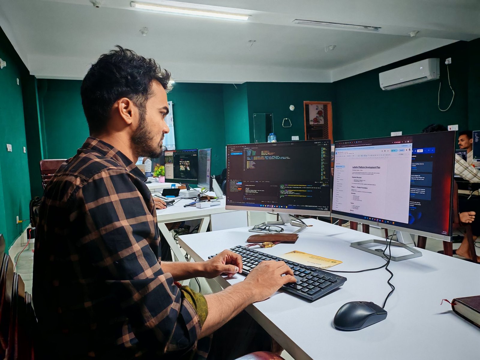 Focused software developer working at a dual-monitor setup