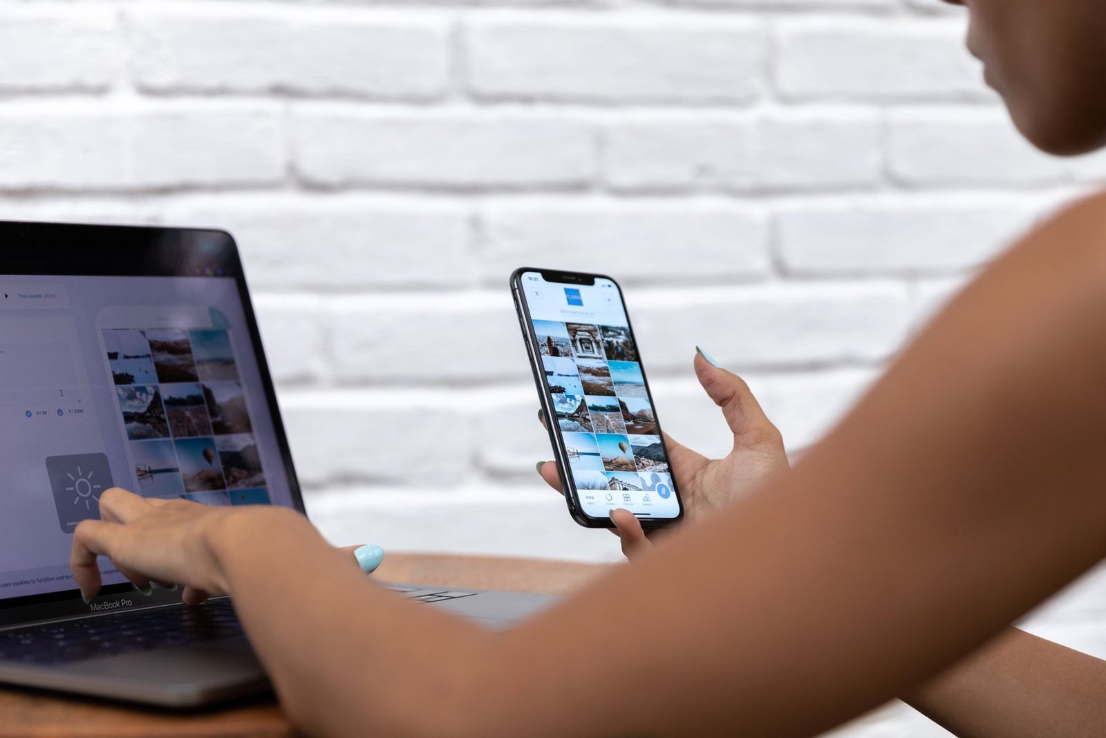 Professional working across a laptop and smartphone for a connected mobile product workflow